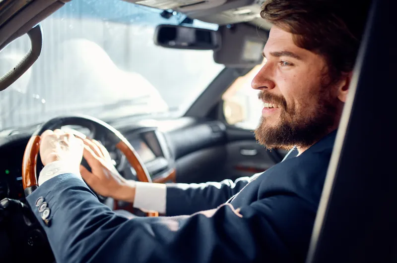 Бородатый мужчина ведет машину во время путешествия