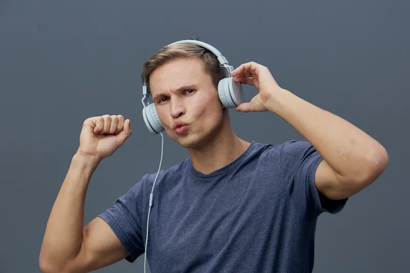 young man with headphones listening music enjoying sound isolated gray background digital detox relaxation concept