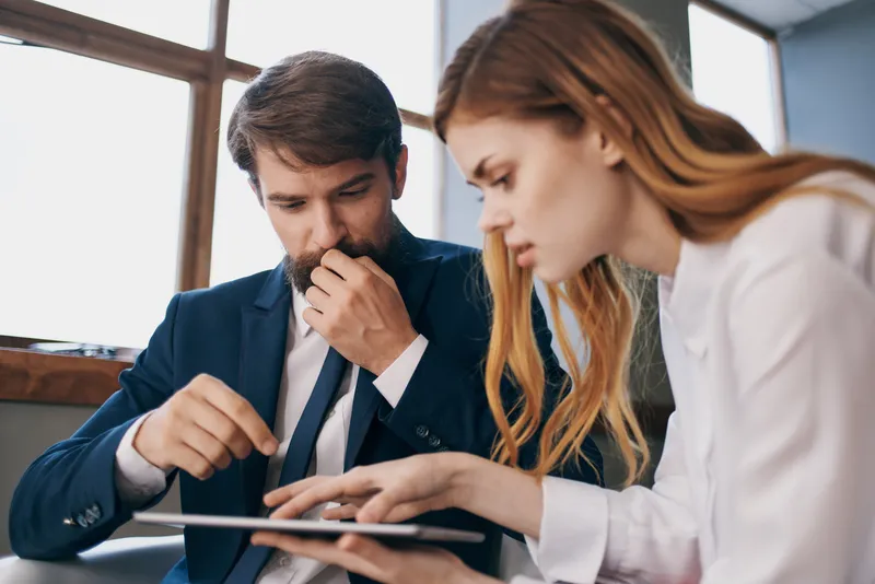 Мужчина и женщина работают с планшетом в технологичном офисе