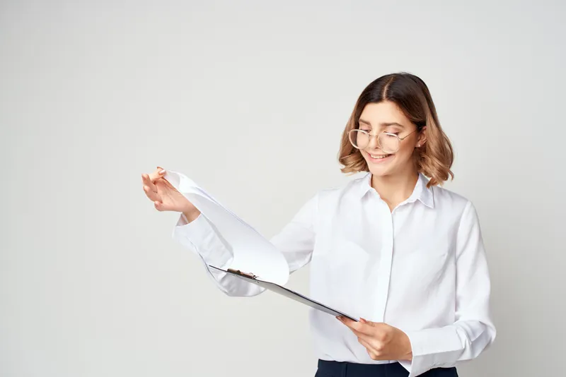 Жизнерадостная женщина-менеджер в белой рубашке, документы, работа, профессионализм