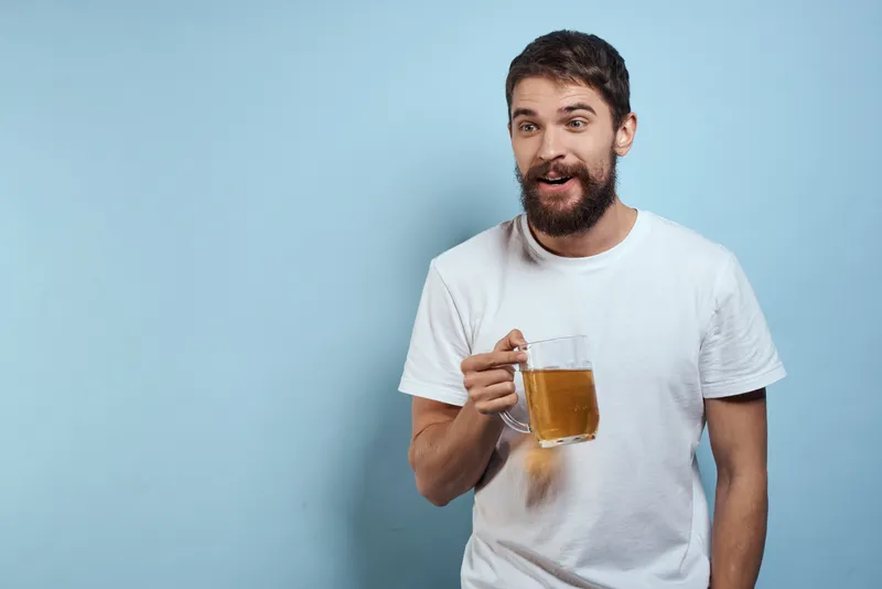 Веселый пьяный мужчина с пивной кружкой, диетическая еда, веселье на синем фоне