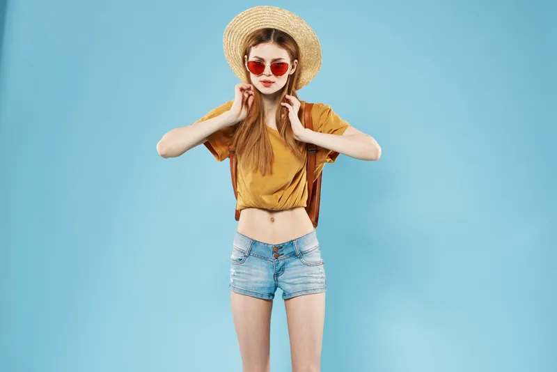 Симпатичная женщина в модной летней одежде на студийном изолированном фоне
