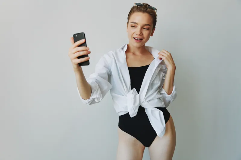 Девушка-подросток, ведущая блог, фотографирует и снимает себя на видео на свой телефон для создания контента для социальных сетей