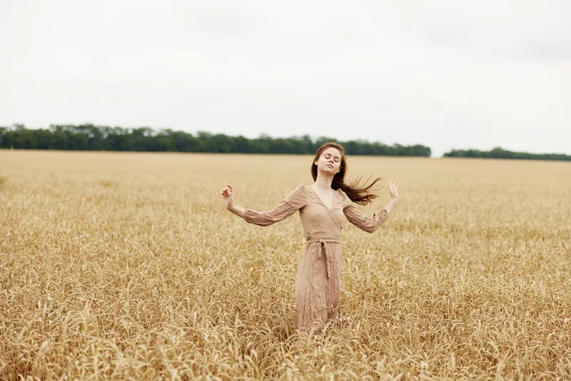 Симпатичная женщина на фоне сельской местности, промышленности и возделанных бескрайних полей