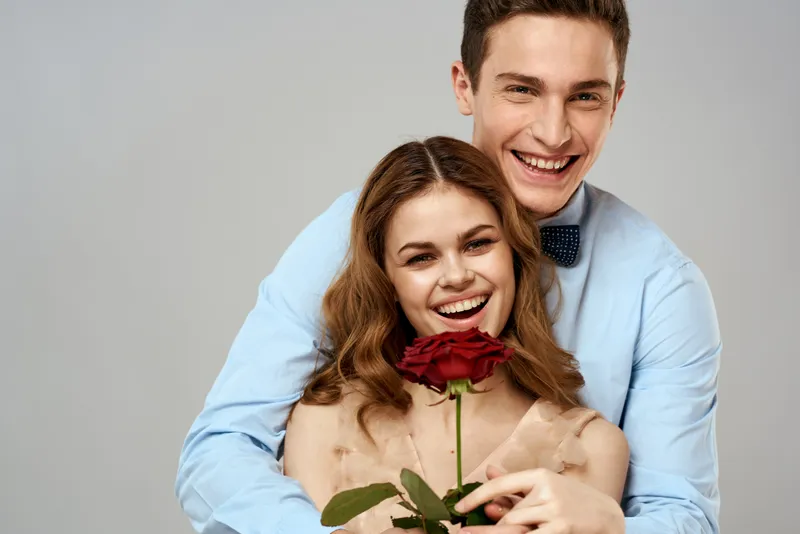 Весёлая молодая пара, романтика, объятия, отношения, красная роза, образ жизни, светлый фон