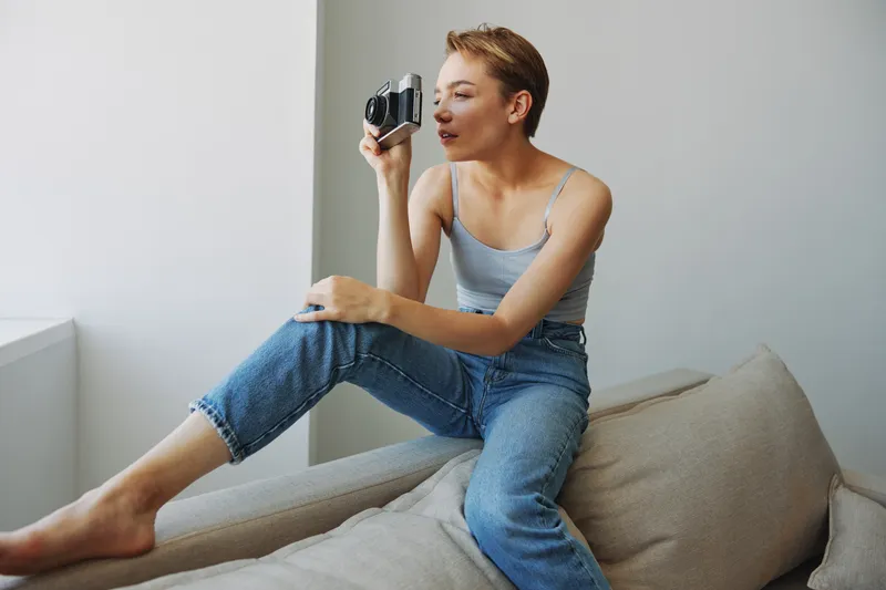 Женщина-фотограф снимает в студии на старую плёночную камеру