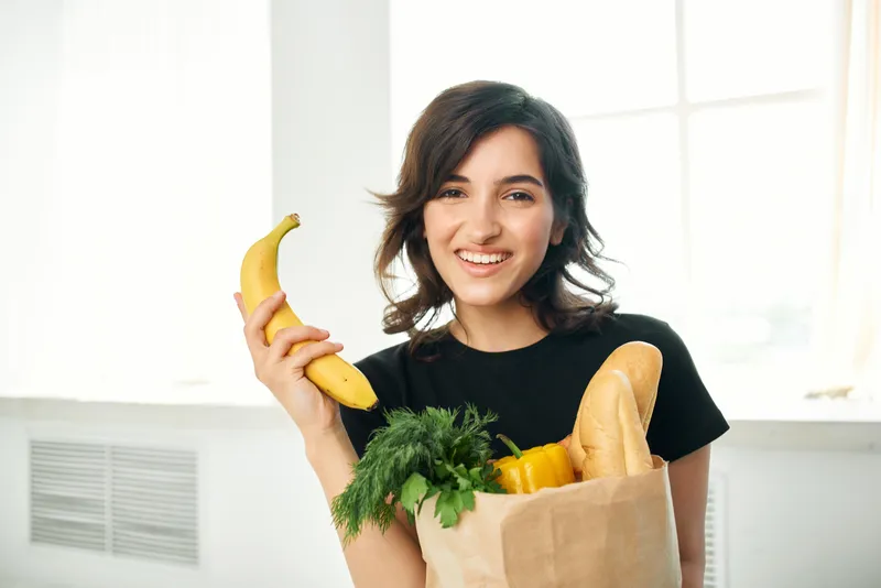 Женщина на кухне с пакетом продуктов готовит еду, доставка еды, здоровье