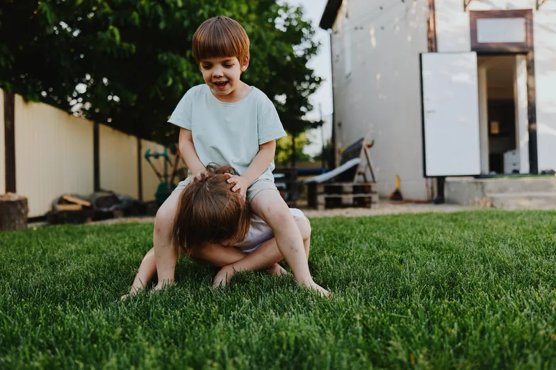 Happy children playing outdoors, enjoying a sunny day in the garden. Laughter and joy fill the atmosphere while they engage in fun activities together.