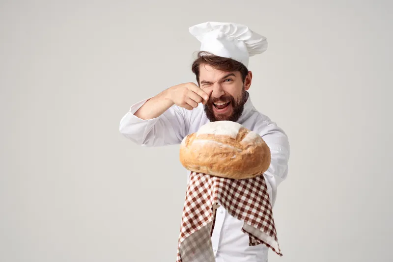 Пекарь с хлебом в руке на изолированном фоне