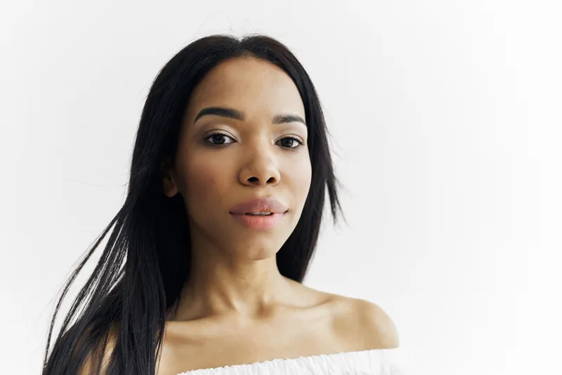 Привлекательная женщина африканской внешности позирует в модном образе, кадр обрезан