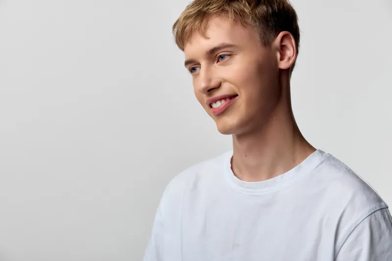 Smiling, young, man, casual, white, t, shirt, neutral, backdrop, friendly, mood, relaxed, vibe, everyday, style, positive, energy, bright, expression, clean, background, approachable, look, youthful,