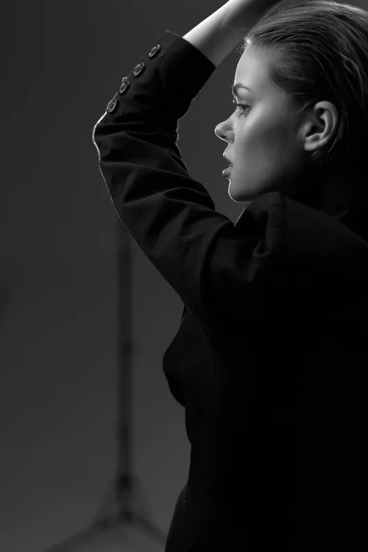 Black and white portrait of a thoughtful woman in a blazer expressing confidence and elegance.