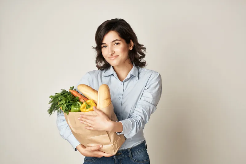 Брюнетка с пакетом продуктов здорового питания «Органика» в строительном магазине