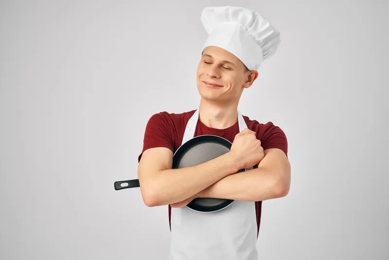 Мужчина в форме шеф-повара занимается приготовлением пищи
