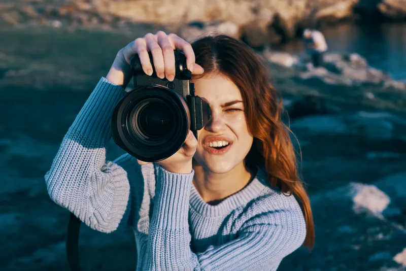 Женщина-фотограф на фоне скалистых гор, путешествие, отпуск, свежий воздух