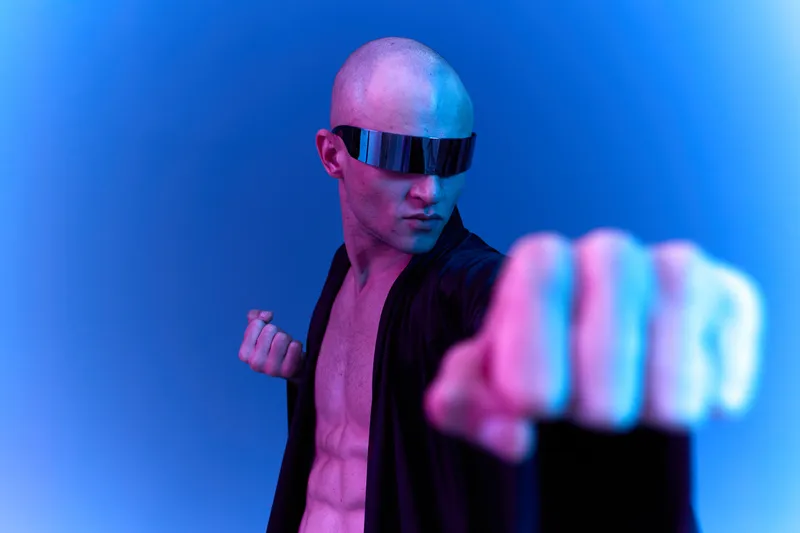 Powerful man in futuristic attire striking a dynamic pose, showcasing strength and determination. The image features vibrant light patterns and a sleek design.