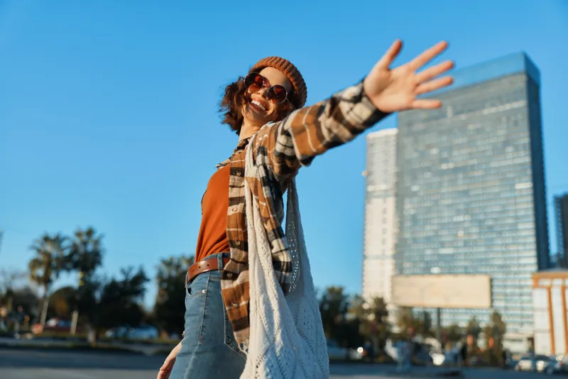 Woman smile urban sunlight walking joy, carefree portrait of a stylish city dweller with authenticity and candid lifestyle vibe, golden hour glow, mindful living and emotional storytelling.