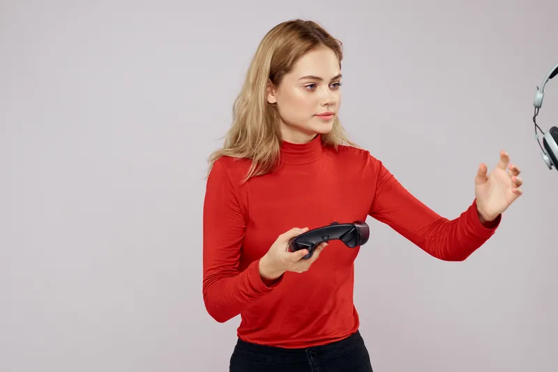 Женщина с геймпадом в руках играет в игры