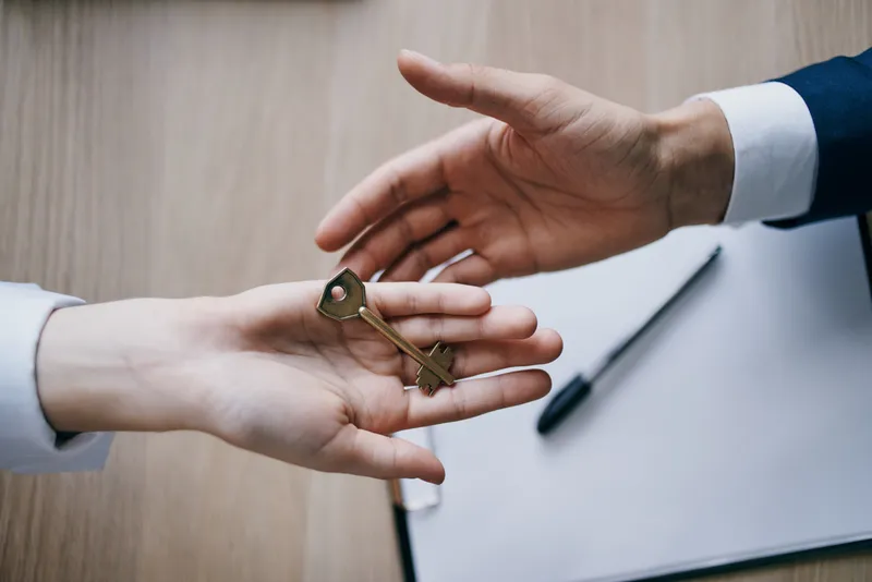 Ключ в руках как символ заключения договора о продаже квартиры через агентство