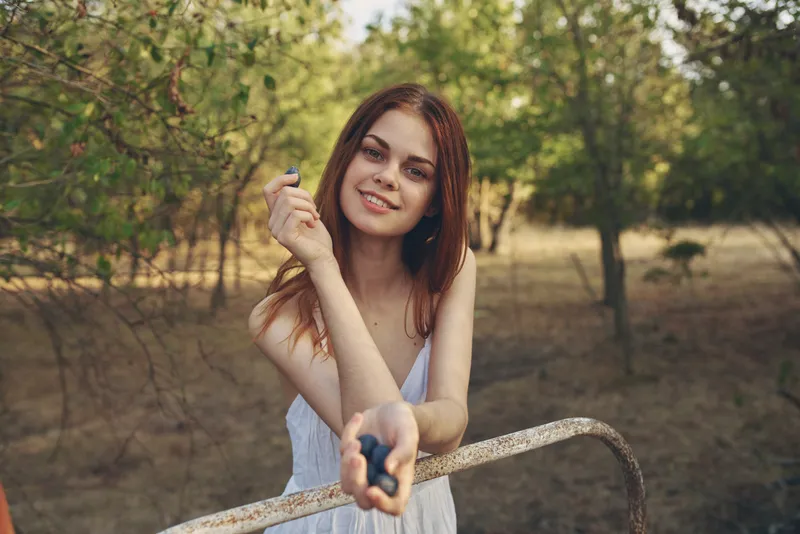 Женщина в белом платье гуляет на природе летним днем