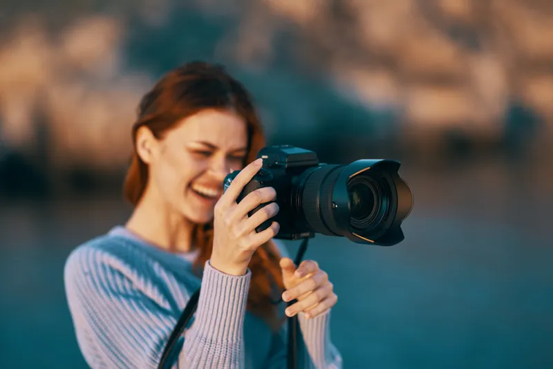 Женщина-туристка с фотоаппаратом на природе