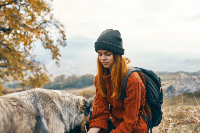 Женщина-туристка обнимает собаку на природе, патриархальный отдых
