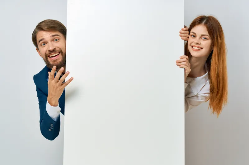 Забавные бизнесмен и женщина с белым постером, презентация, место для текста