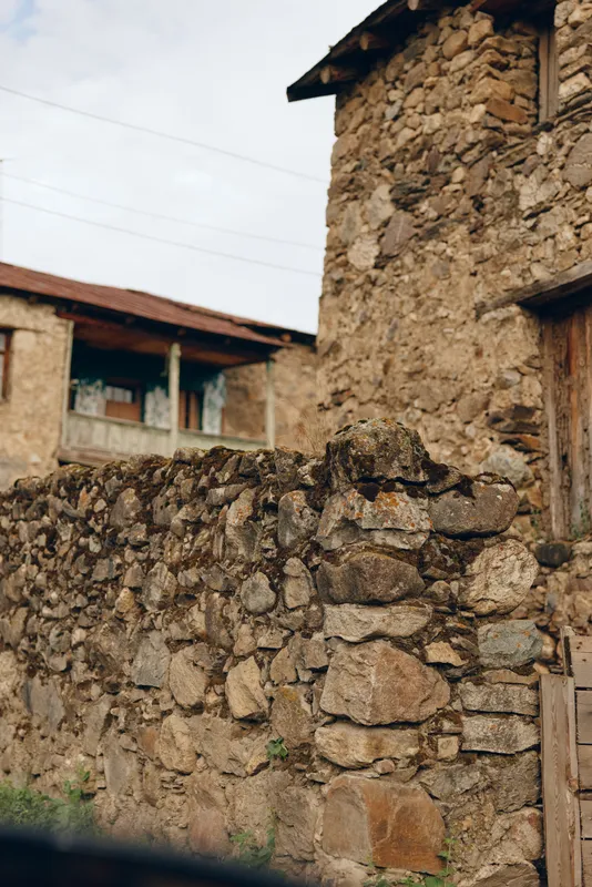 Stone wall village building rustic masonry texture doorway facade in rural old town with weathered stones