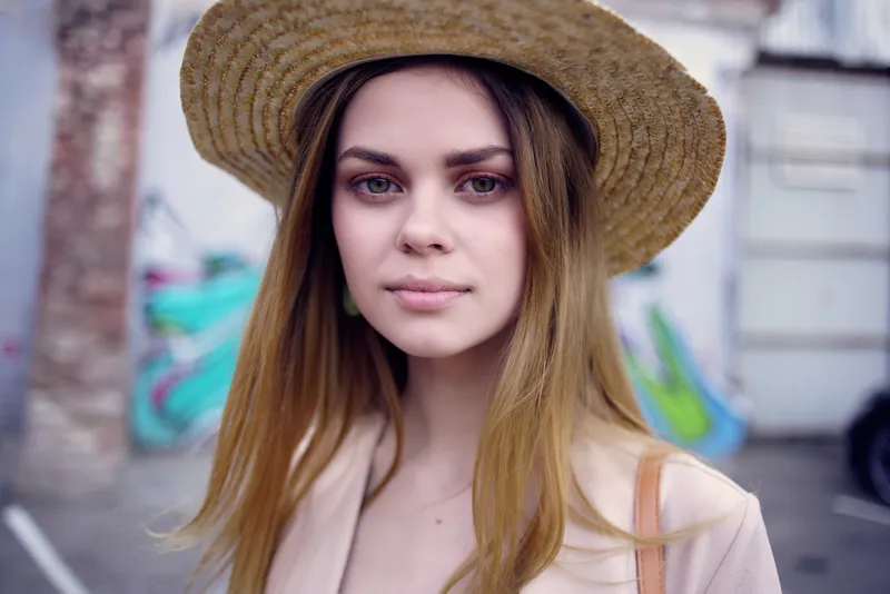 Симпатичная женщина на улице в шляпе и очках, модель