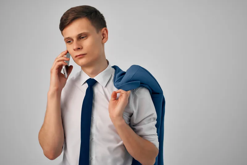 Менеджер с пиджаком на плече разговаривает по телефону, профессиональная работа