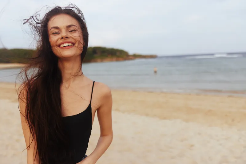 Отдыхающая женщина расслабляется у воды на пляже
