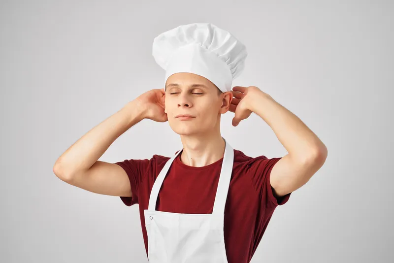Мужчина в фартуке на кухне, профессиональный светлый фон, шеф-повар