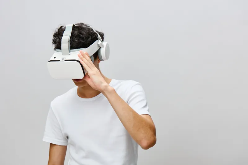Погружение в виртуальную реальность: молодой человек в современном VR-шлеме демонстрирует сосредоточенность и увлечённость