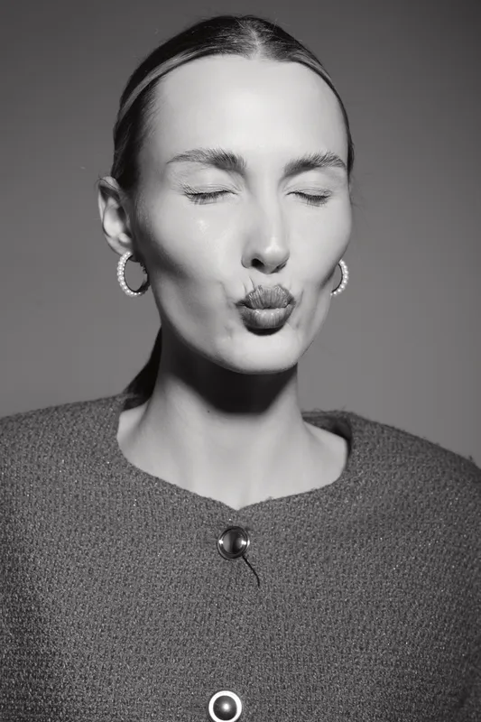 Young white woman with pale skin and closed eyes sending a kiss in studio. Concept of affection, beauty, and portrait.