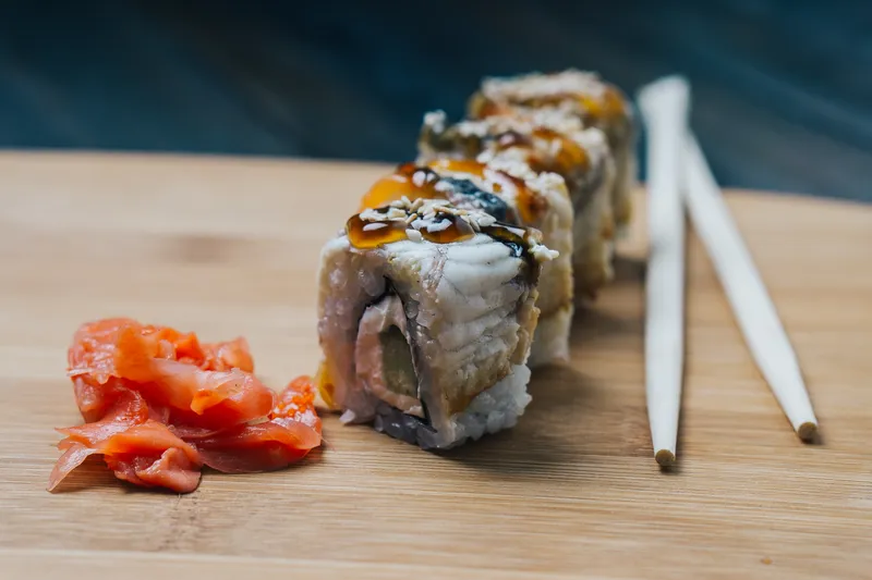 Японская кухня: суши, соус, палочки, имбирь на деревянной доске