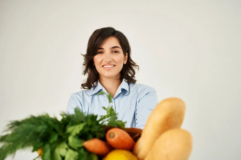 Симпатичная брюнетка с пакетом продуктов из супермаркета