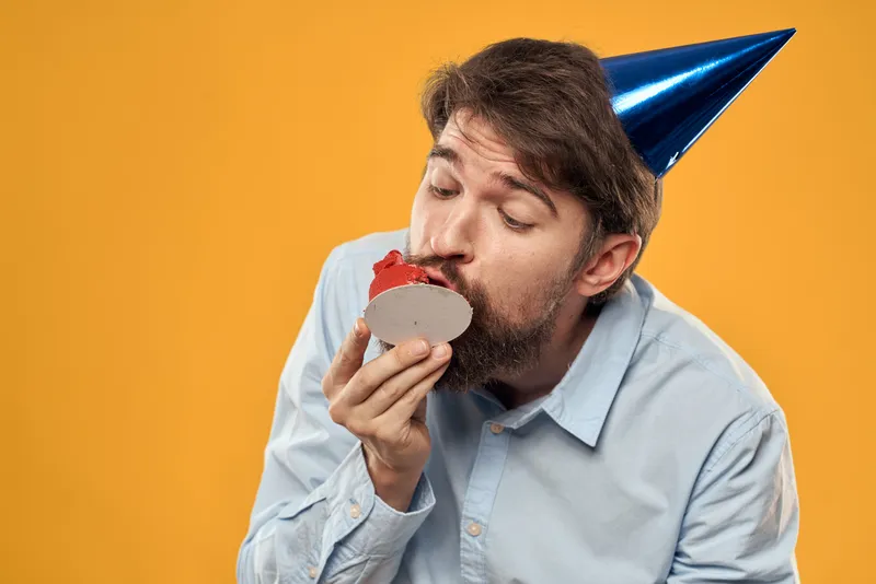 Весёлый мужчина ест торт, праздник, день рождения, веселье, жёлтый фон