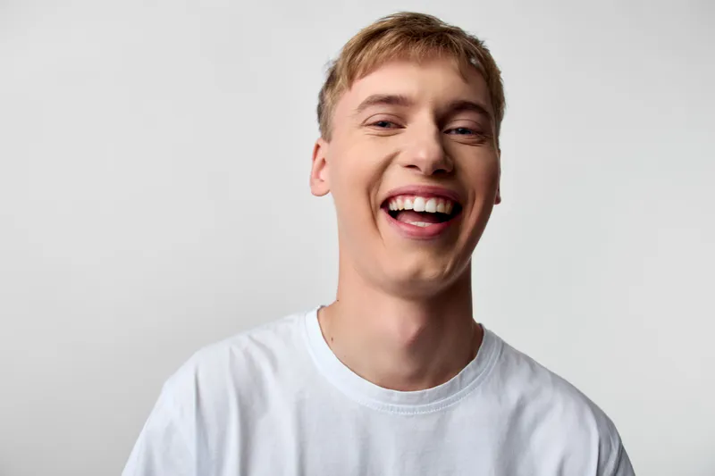 Bright closeup of a smiling man in a white tee, radiating happiness, casual style, and a friendly vibe, ideal for lifestyle, upbeat campaigns, and social media use
