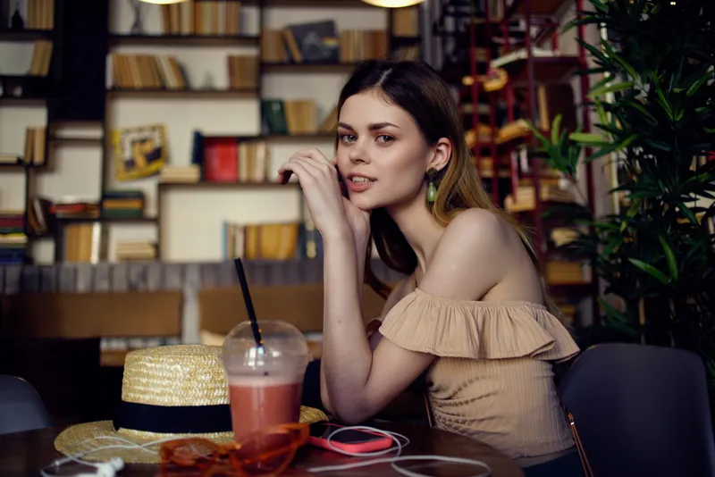 Симпатичная женщина читает книгу в кафе, общаясь