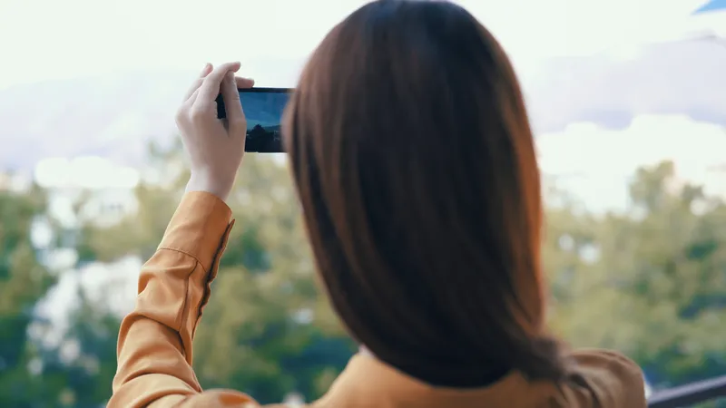 Высококачественная фотография: женщина с телефоном в руках фотографирует природу на открытом воздухе, панорама