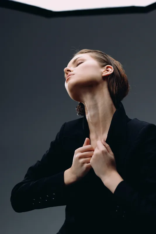 Portrait of a thoughtful woman in black jacket with closed eyes and raised head expressing calm and confidence