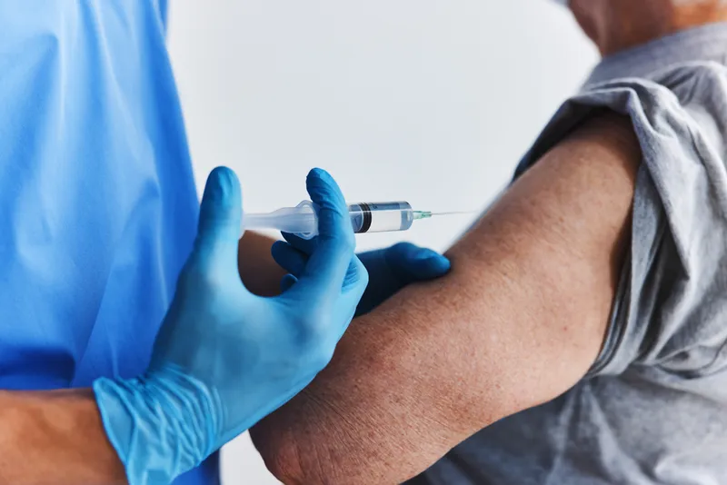 Рука врача-мужчины делает инъекцию вакцины, паспорт вакцинации, защита иммунитета