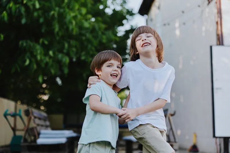 Happy boys playing together in a sunny garden, enjoying their carefree childhood moments and filled with laughter and joy in a vibrant outdoor setting.