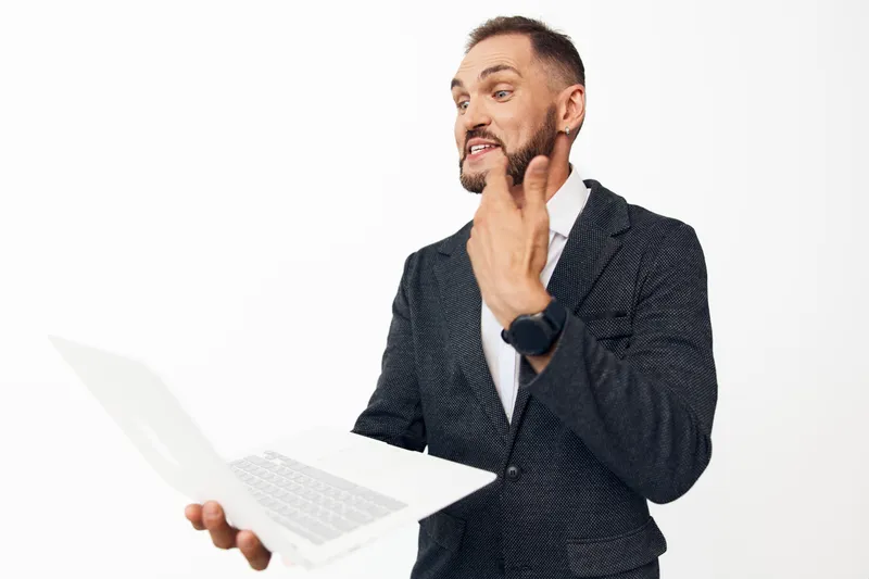 A professional business man on an isolated colored background, presenting a laptop, radiating confidence, focus, and positive energy during a briefing.