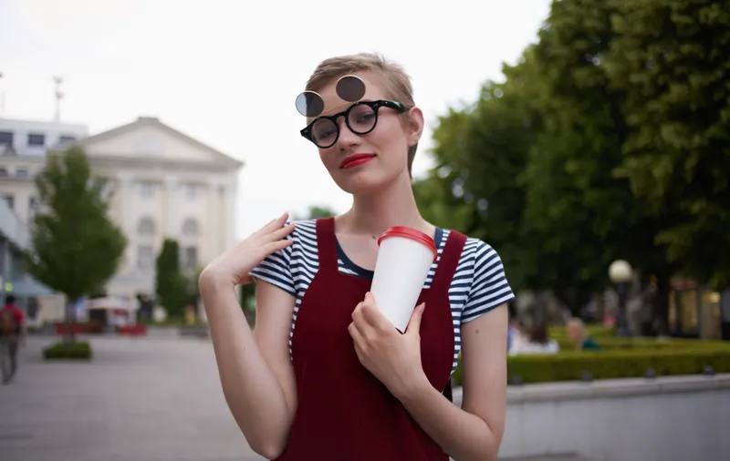 Модная женщина в сарафане и очках на лице, улица, природа, лето, деревья, здание
