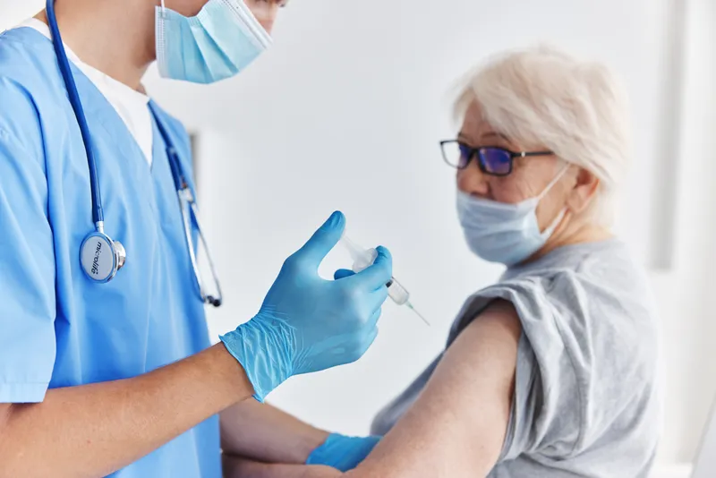 Врач и пациент, вакцинация в плечо, паспорт вакцинации в больнице