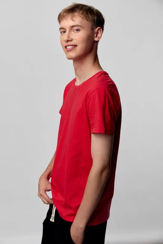 Casual red shirt on a smiling male model in a studio with a plain background, relaxed pose, showcasing everyday wear, modern street style and comfortable cotton fabric