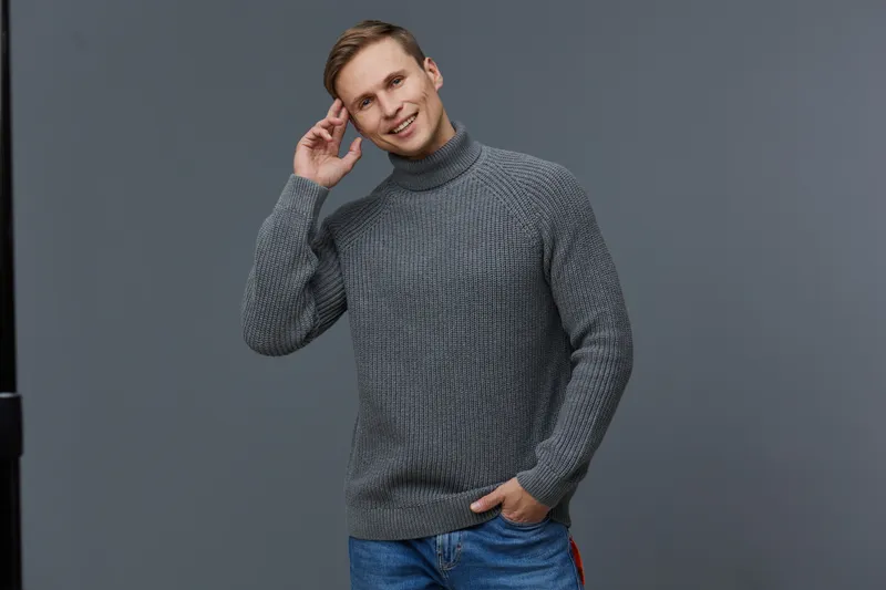 smiling man wearing knitted gray sweater casual jeans isolated on gray background touch head concept digital nomad work lifestyle