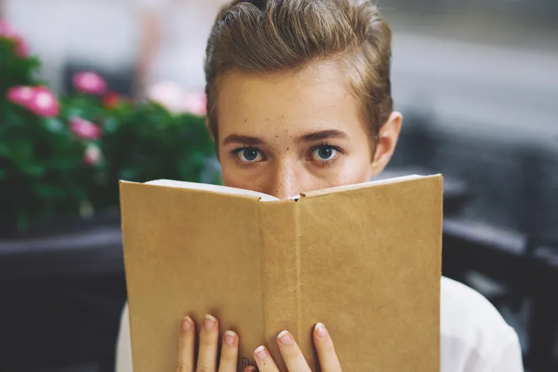 Студент с книгой в руках: чтение, прогулка на свежем воздухе, образование