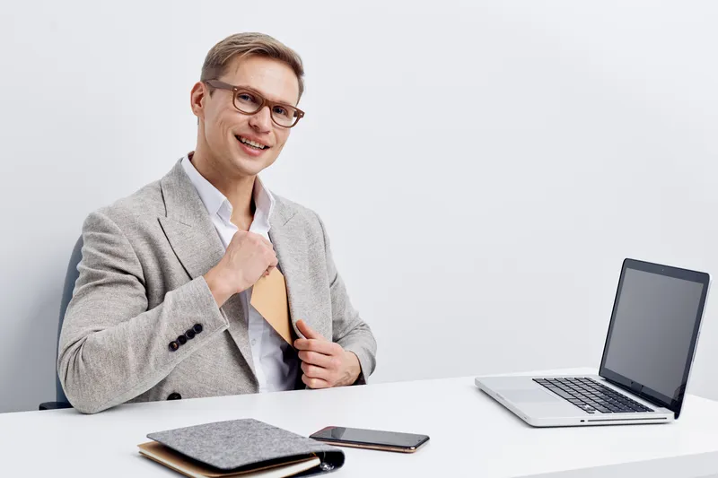 smiling man using laptop phone in gray jacket work digital nomad lifestyle with wireless gadgets on white background